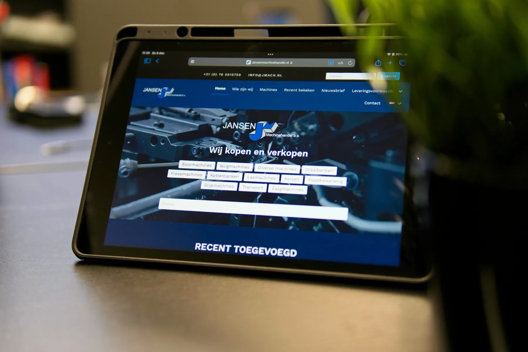 Een tablet in de studio toont de website die ZwaarVet bouwde voor Jansen Machinehandel
